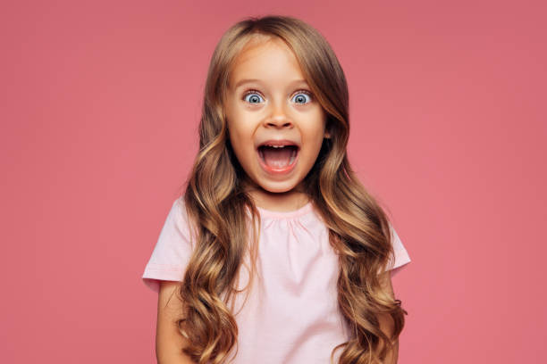chica divertida sobre fondo rosa - child surprise little girls human face fotografías e imágenes de stock