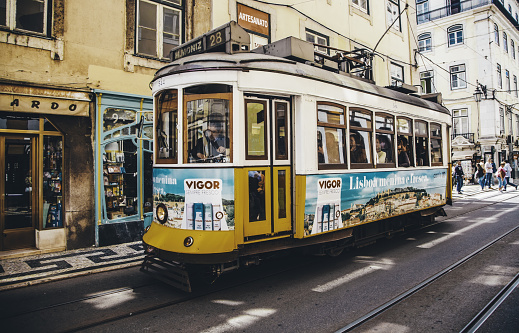 Lisbon, Portugal - April 19, 2014: Street view with famous old tourist tram full of people during the sunny day in Lisbon city, Portugal