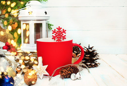 Christmas and New Year decorations with red cup and fir branch on white bacground. Winter mood, copy space