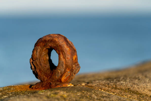 A close-up of a rusty mooring eyelet on the North Shields pier on the banks of the Tyne estuary. This is  a close-up of the rust and weathering on the eyelet.