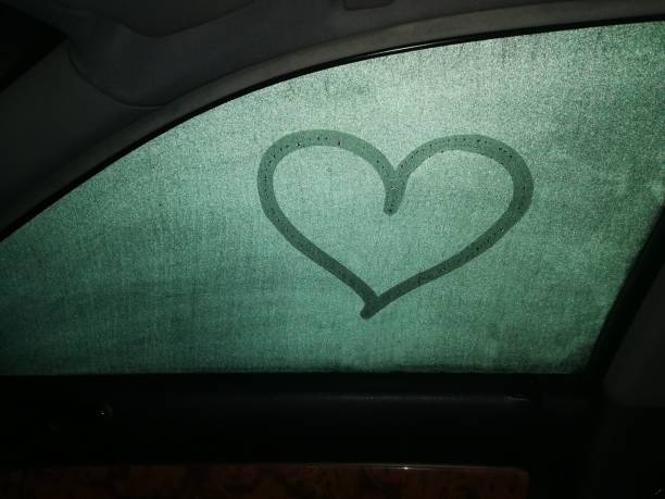 istock Painted heart on a dewy car window, view from inside, it's dark outside 1285137565