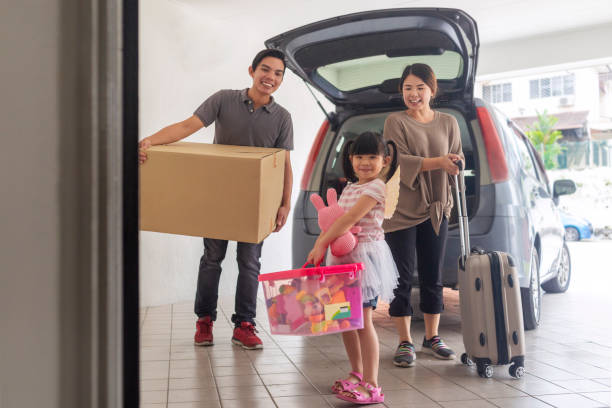 istock happy family carrying stuff into their new home 1285140198