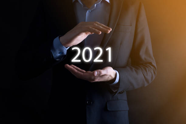 istock Businessman with protective gesture standing posture hand holding 2021 word inscription. 1285140410