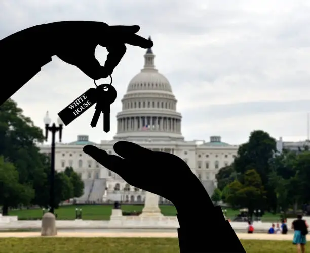 Illustration of the concept of presidential transition after elections before taking over the administration of the federal government. Passing white house keys with blurred white house in background