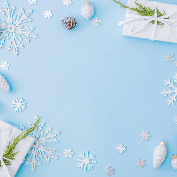 istock Flat lay christmas frame with snowflakes, balls and gift box on a blue background 1285141727
