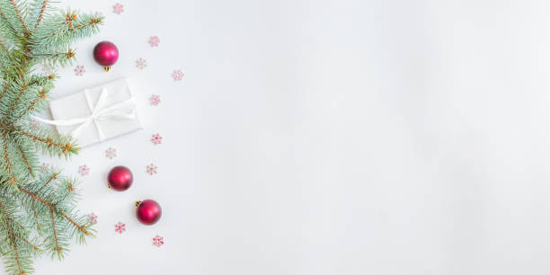 istock Flat lay frame with fir branches, christmas baubles decoration and gift box on a white background 1285141730