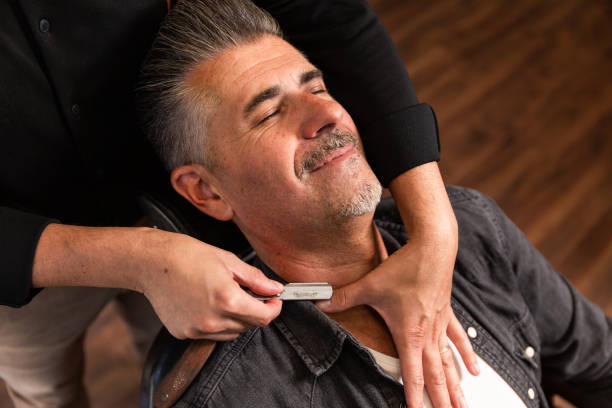 barber's hands about to shave a customer's beard with a razor the hands of a Caucasian barber about to shave a client's beard with a classic razor in the barber shop. switchblade stock pictures, royalty-free photos & images