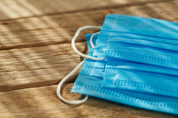 istock Group of surgical protective face masks on wooden surface 1285144232