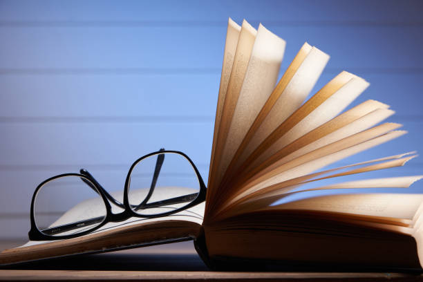 Eye glasses are laying on a book . selective focus