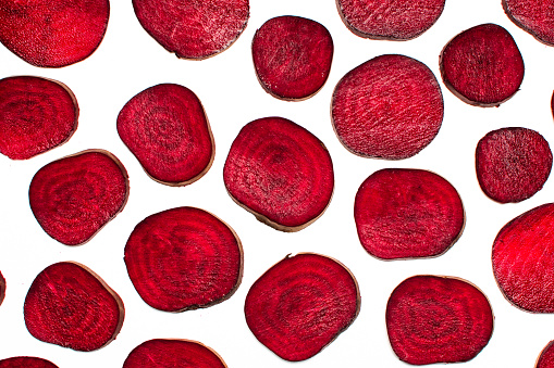 Organic raw red beet root slices flat lay on white background isolated top view