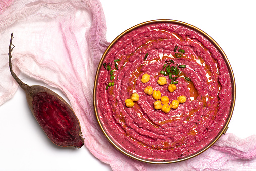 Healthy vegan hummus with beet root in a bowl top view. Beet and chickpeas is valuable source of protein, vitamin C and others