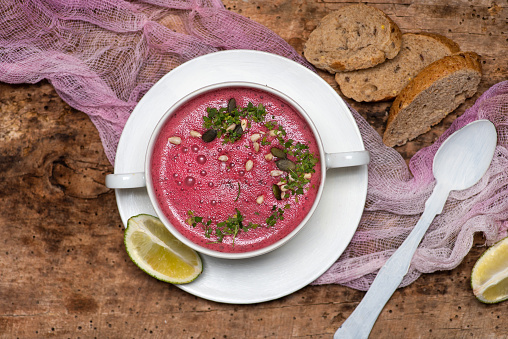 Healthy beet root cream soup with parsley and nuts in a bowl. Healthy organic food for detox