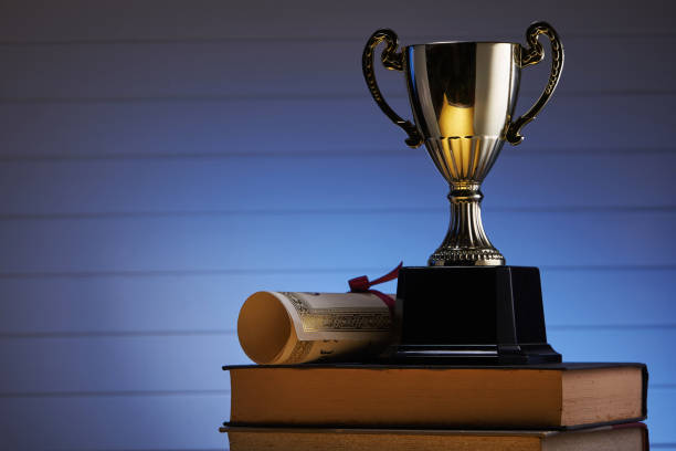 istock Golden trophy and book, learning and achievement concept 1285145766
