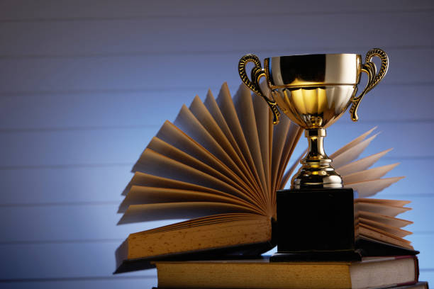 istock Golden trophy and book, learning and achievement concept 1285145802