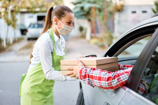 istock Order Being Passed Between Hands Through Car Window Outside Restaurant During Covid-19 Lockdown 1285148300