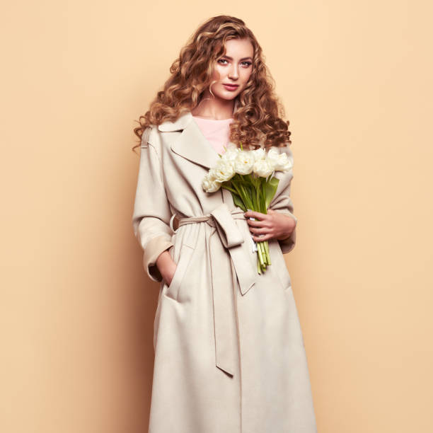 istock Young woman in white spring coat 1285148485