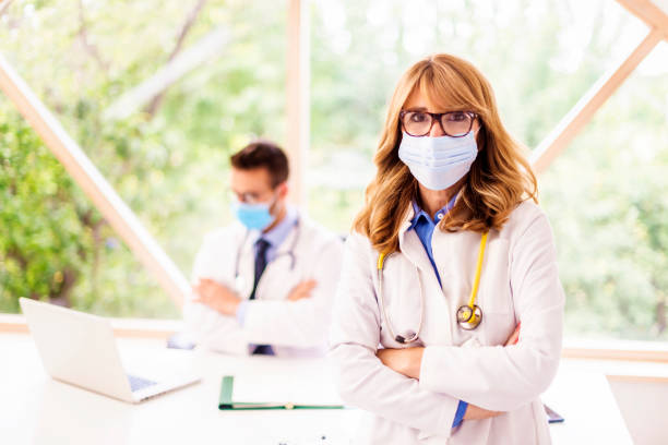 istock Female doctor wearing face mask while standing at doctor's office 1285148641