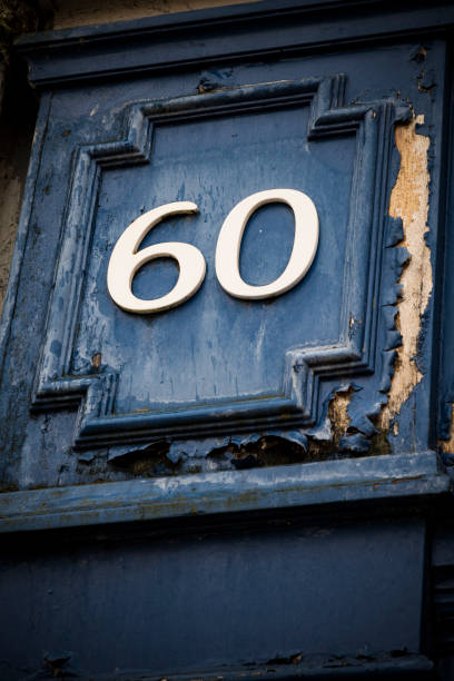 istock Number sixty on weather painted blue door 1285149580