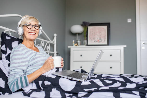 istock Senior woman in bed using laptop 1285154943