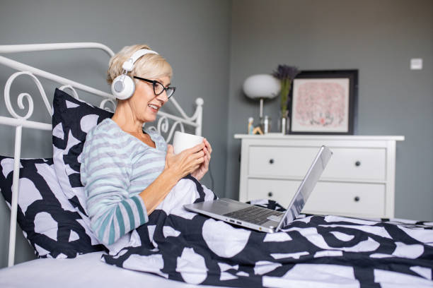 istock Senior woman in bed using laptop 1285154948