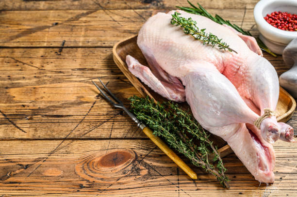 istock Raw whole farm duck with herbs. wooden background. Top view. Space for text 1285156031