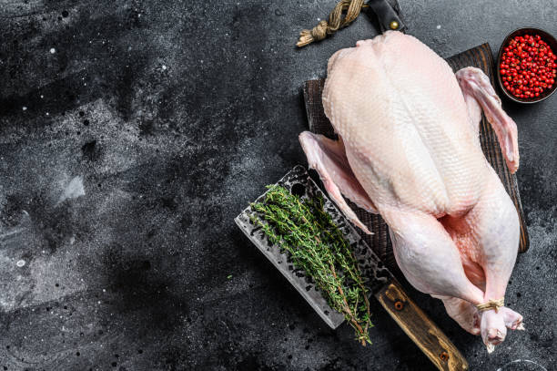 istock Raw whole duck, poultry meat. Black background. Top view. Space for text 1285156094