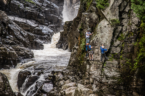 Sainte Anne Cayon, Canada - August 21 2020: Tourists climbing through Via ferrata in Sainte Anne Cayon in Quebec