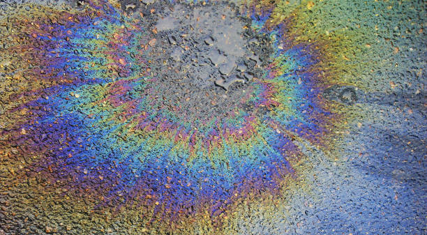 istock Petrol oil spill on asphalt road background or texture. Polution environment concept 1285156737