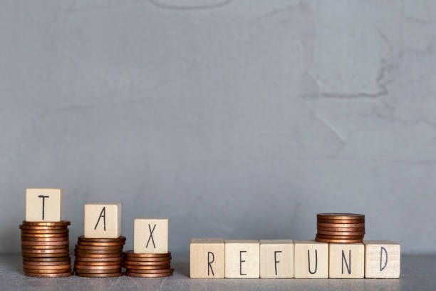 istock Tax refund text with wooden cubes on concrete modern background texture and stacking coins 1285157843