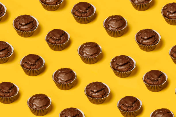 istock Chocolate cupcakes or cookies pattern on a yellow background. Summer minimalism. Isometric flat lay. Top view. Food concept. 1285158900
