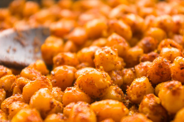 Cooking chickpeas with spices in a pan, close up