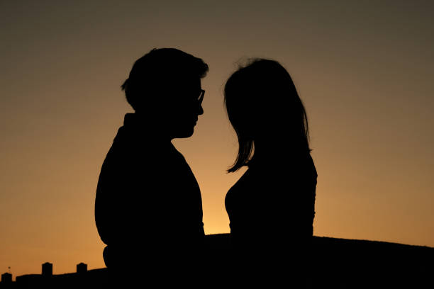 casal iluminado ao nascer do sol - sunrise beach couple hiking - fotografias e filmes do acervo