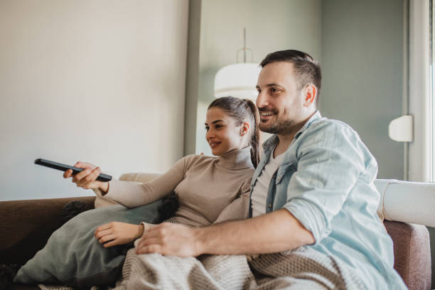istock Young couple watching TV at home 1285164014