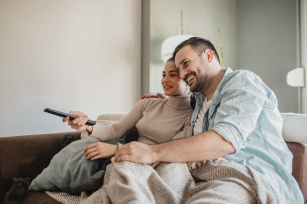 istock Young couple watching TV at home 1285164094