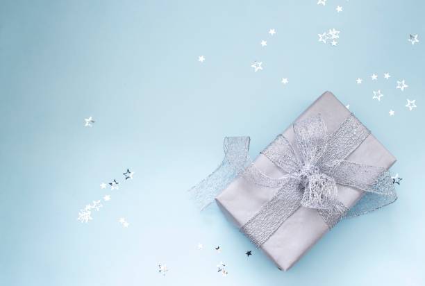 istock christmas gift with silver ribbon on blue background 1285164108