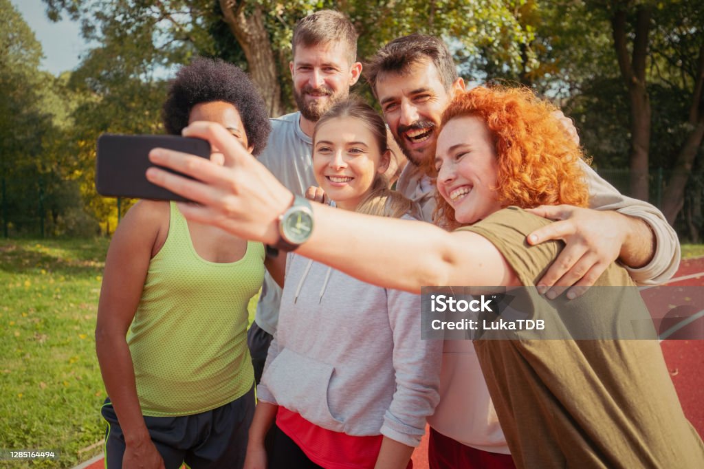Everything is nicer in a good company A small group of friends is taking a selfie on the trim track. They are standing embraced and smiles on their faces are wide. 20-24 Years Stock Photo
