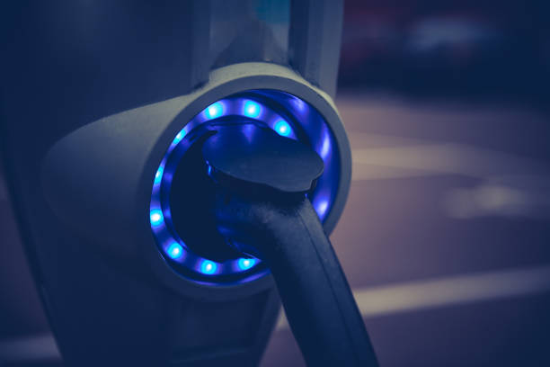 type 2 car charger socket, plug port cable on electric vehicle in a male hand at an electric car charging station