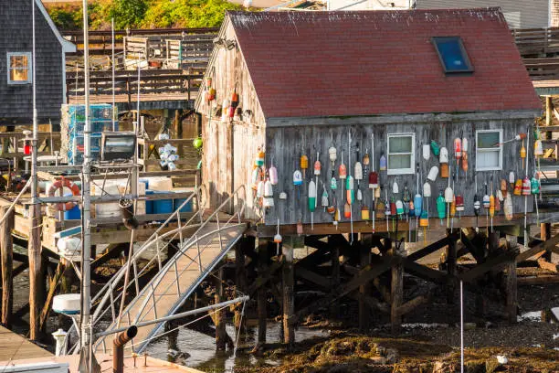 Photo of Wooden fishing hut at the end of pier in harbour at sunset