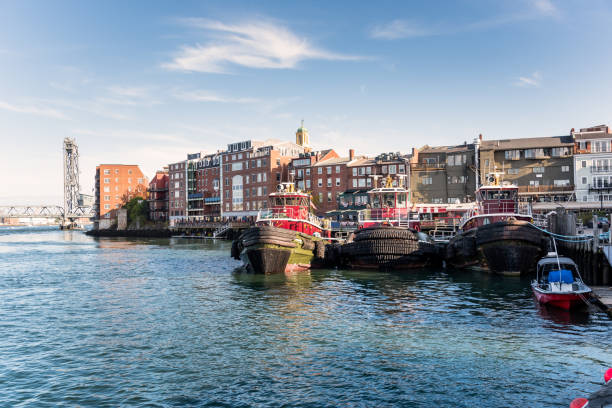 View of Portsmouth waterfront on a clear autumn day Portsmouth skyline on a sunny autumn day. Moored tug boats are visible in in foreground. New Hampshire, USA. portsmouth nh stock pictures, royalty-free photos & images