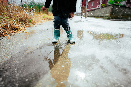 Photo of a young boy having fun outdoors on a rainy day.