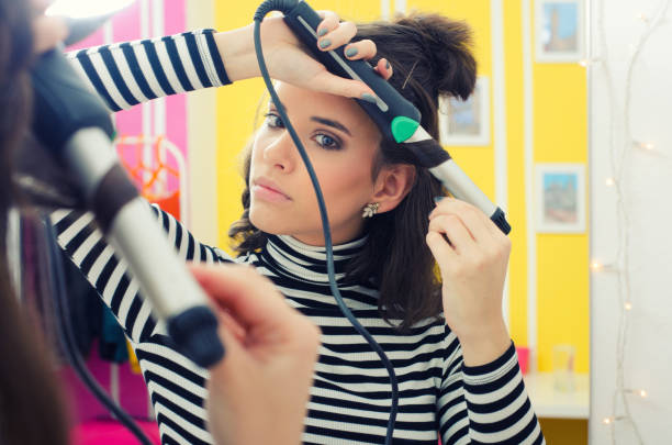 istock Young woman curling long hair 1285167487