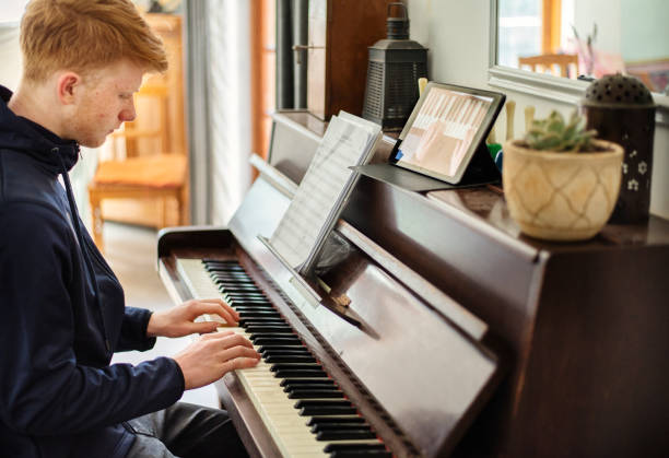 istock Boy playing piano during an online class at home 1285167766