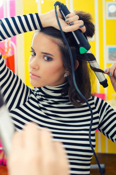 istock Young woman curling long hair 1285167803