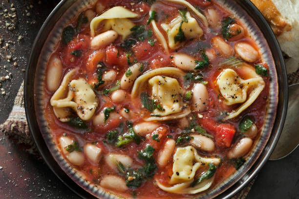 włoska biała fasola, zupa tortellini ze szpinakiem i marchewką w bulionie pomidorowym - tomato sauce tomato spinach soup zdjęcia i obrazy z banku zdjęć