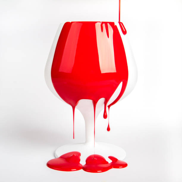 istock red paint pouring on white objects- apple and wineglass 1285170046