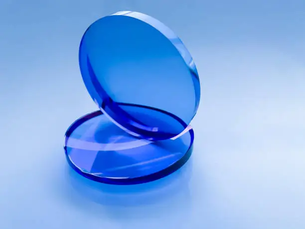 two blue optical sun-protection plastic lenses for correction of myopia on a dark background.