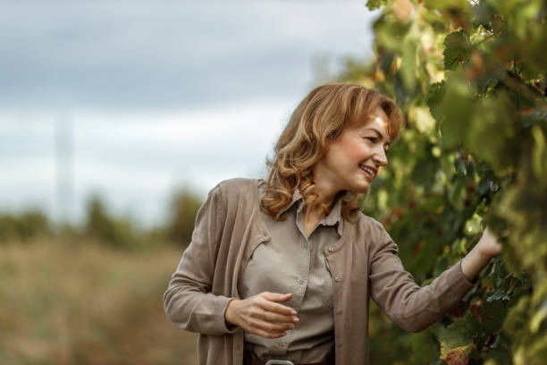 istock Smiling woman looking for fruits from tree. 1285170851