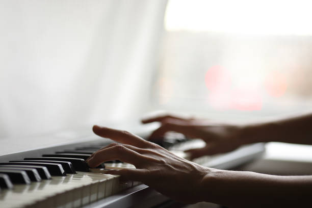istock Hands on the keyboard of a gray electronic piano 1285171637