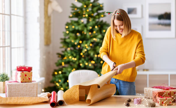 happy   woman gets ready for christmas and wrapping a gift