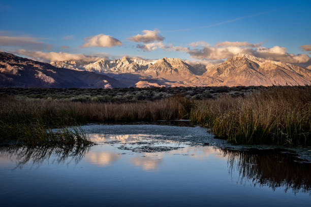 istock Early morning light illuminates snowy mountains and clouds with reflection in water 1285171959